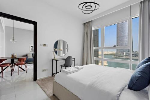 um quarto com uma cama grande, uma mesa e cadeiras em Silkhaus Spacious 1 BDR Al Fay Park Nearby em Abu Dhabi