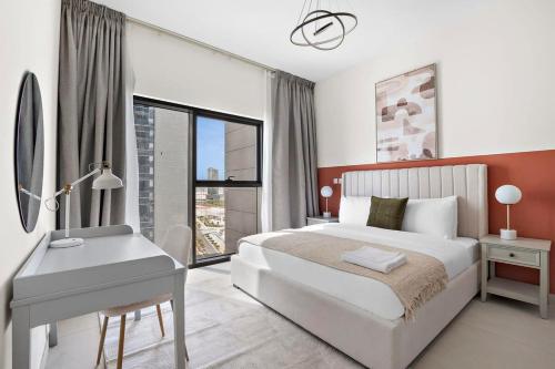 Schlafzimmer mit einem weißen Bett, einem Schreibtisch und einem Fenster in der Unterkunft Silkhaus Spacious 2 BDR Reem Central Park Nearby in Abu Dhabi