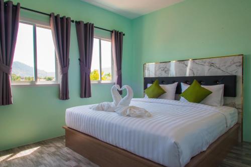 two swans are sitting on a bed in a bedroom at Anatasia Apartment Phuket in Phuket