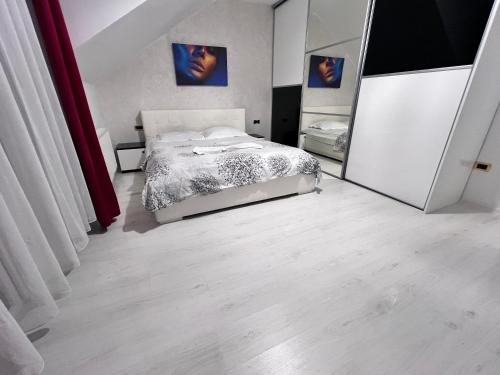 1 dormitorio con cama y espejo grande en Comfy condo Floresti, en Floreşti