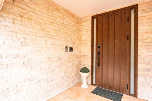 a bathroom with a toilet and a wooden door at 完全貸切別荘 天然温泉 La Saison inn Kirishima 888 in Kirishima