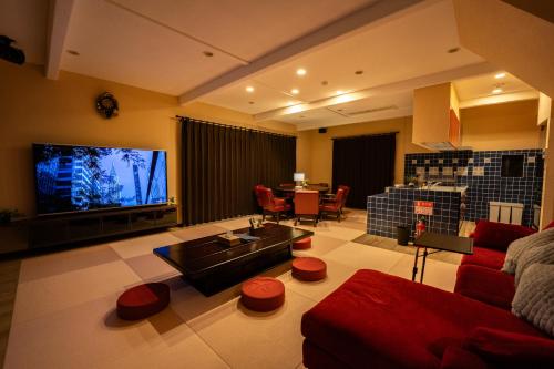 a living room with a red couch and a tv at 完全貸切別荘 天然温泉 La Saison inn Kirishima 888 in Kirishima