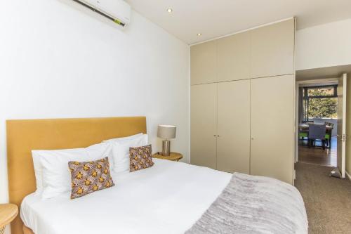 una camera da letto con un grande letto bianco con cuscini di Luxury 2 Bedroom with roof deck and pool a Città del Capo
