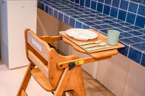 a wooden table and chair with a blue tiled wall at 完全貸切別荘 天然温泉 La Saison inn Kirishima 888 in Kirishima