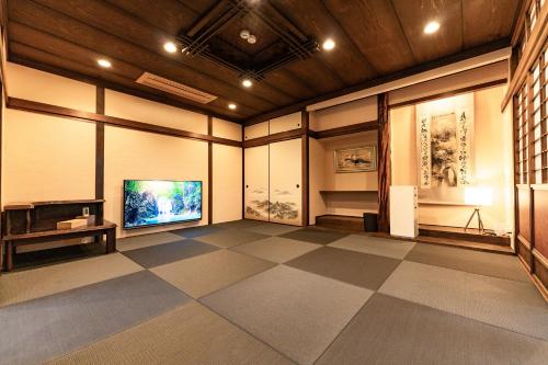 a large room with a television and a tiled floor at 完全貸切別荘 天然温泉 La Saison inn Kirishima 888 in Kirishima