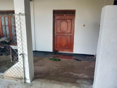 una stanza vuota con una porta in legno in un edificio di STS Roomes / House a Batticaloa