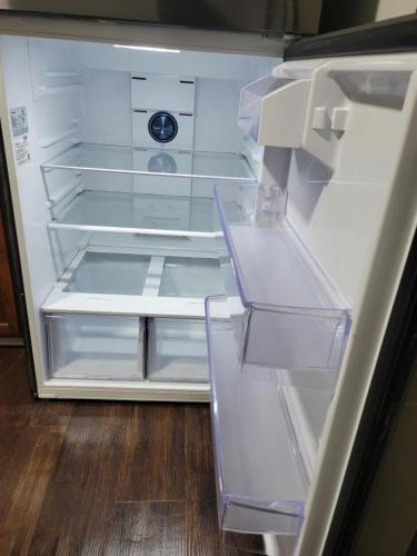 einem leeren Kühlschrank mit offener Tür auf einem Holzboden in der Unterkunft Cozy home in Washington Heights in Chicago