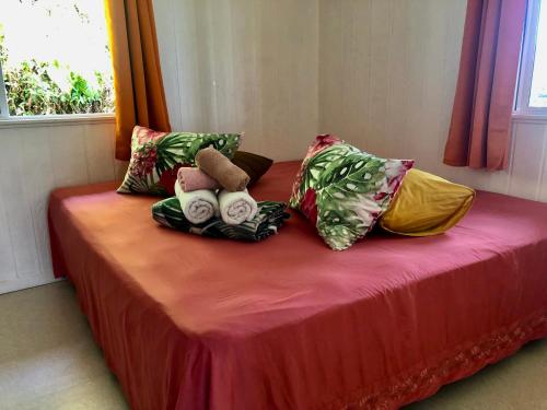 a bed with two stuffed animals on it with pillows at Fare Mirimiri in Uturoa