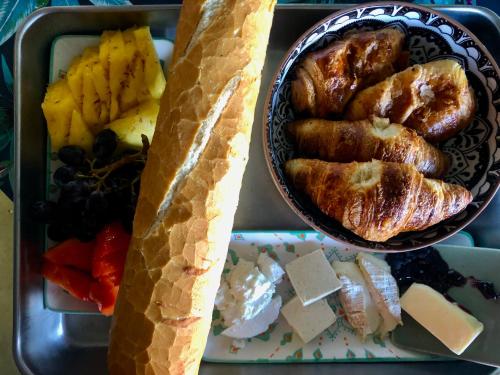 a tray of food with a bowl of bread and fruit at Fare Mirimiri in Uturoa