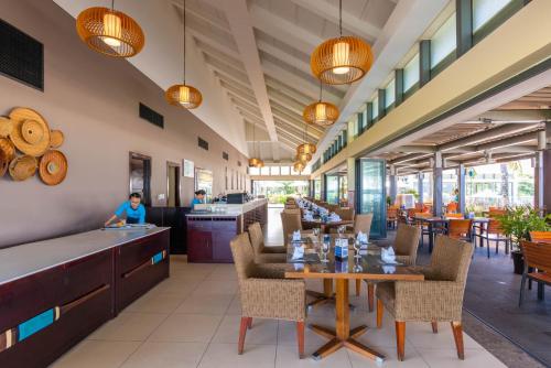 a restaurant with tables and chairs and a person in the background at Memories Holiday beach villa Da Nang in Da Nang