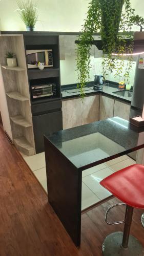 a kitchen with a black counter and a red stool at Cabañas Habitainer BordeRio in Concepción