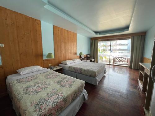 a hotel room with two beds and a balcony at Silversand Villa Hotel in Jomtien Beach
