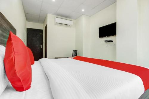 - une chambre avec un lit blanc et un oreiller rouge dans l'établissement Hotel Dev S Villa, à Jaipur
