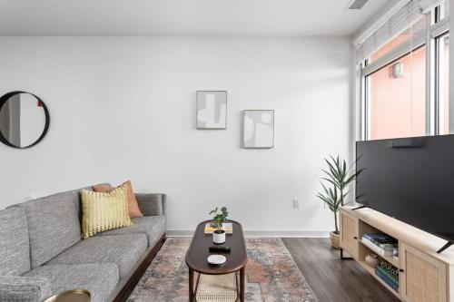 a living room with a couch and a tv at CozySuites l Lavish 1BR, Bottleworks Indy #4 in Indianapolis