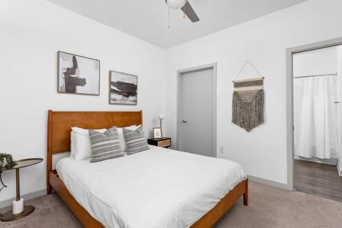 um quarto branco com uma cama grande e uma janela em CozySuites l Dream 1BR, Bottleworks Indy #6 em Indianápolis