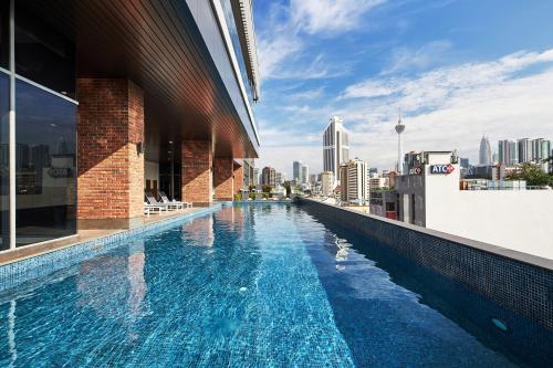 a swimming pool on top of a building with a city skyline at Four Points by Sheraton Kuala Lumpur, Chinatown in Kuala Lumpur