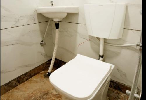 een badkamer met een wit toilet en een wastafel bij Star@Hotel in New Delhi