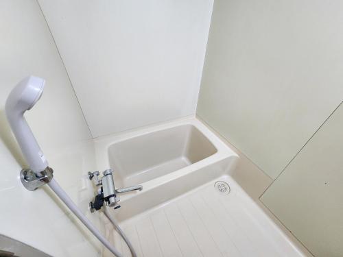 a small white sink in a small bathroom at fukiconoie in Tokachi