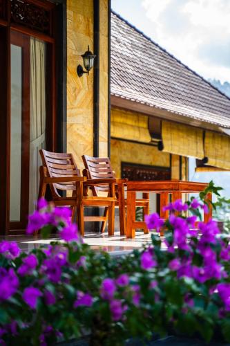 two chairs on the porch of a house with purple flowers at The babakan accommodations in Sidemen