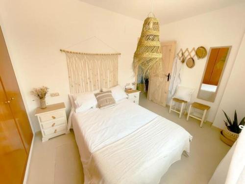 um quarto branco com uma cama e um lustre em Apartamento Miami Playa, 2 dormitorios, 4 personas - ES-9-167 em Les Planes del Rei