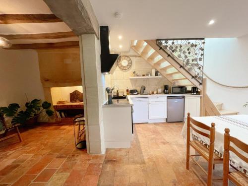une cuisine avec des placards blancs et un escalier dans l'établissement Cosy Gîte à Azay-le-Rideau avec Wifi, Clim, tout inclus, idéal pour 2 adultes et 2 enfants, proche châteaux - FR-1-381-567, à Azay-le-Rideau