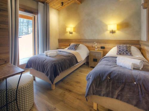 a bedroom with two beds and a window at Chalet La Clusaz, 4 pièces, 6 personnes - FR-1-304-287 in La Clusaz