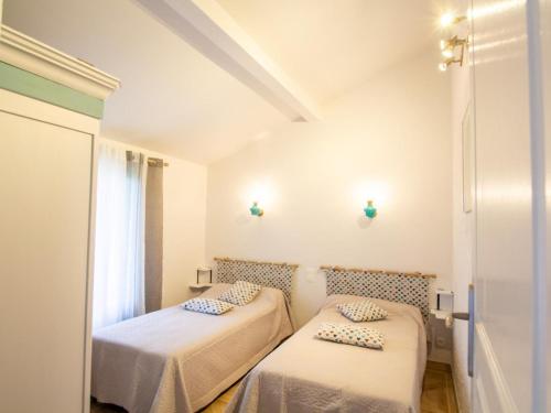 two beds in a small room with white walls at Maison Familiale au Calme avec Ping-Pong, Baby-Foot et Proximité Sites Préhistoriques - FR-1-616-339 in Le Bugue