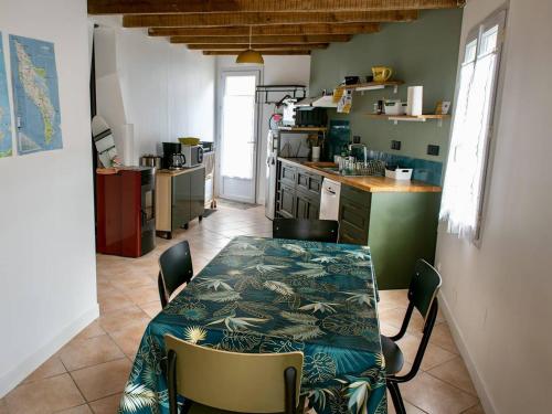 une cuisine avec une table et des chaises dans une pièce dans l'établissement Maison rénovée avec jardin, proche commerces et pistes cyclables - 4 couchages, Le Château-d'Oléron - FR-1-246A-282, au Château-dʼOléron