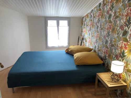 une chambre avec un lit bleu et une fenêtre dans l'établissement Maison rénovée avec jardin, proche commerces et pistes cyclables - 4 couchages, Le Château-d'Oléron - FR-1-246A-282, au Château-dʼOléron