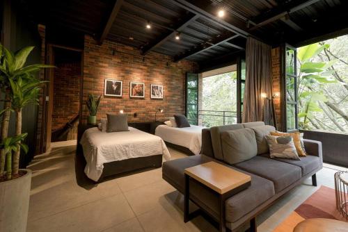 een woonkamer met een bank en een bed bij Hotel Meridiano Lofts in Medellín