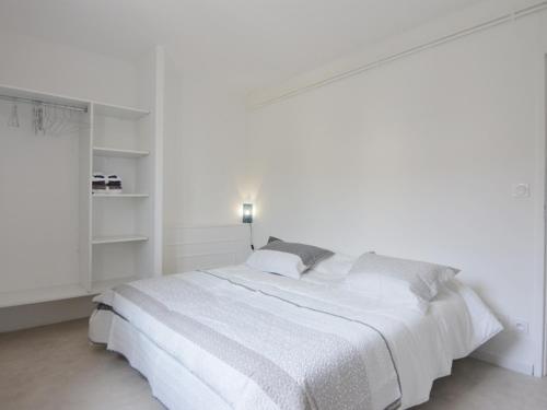 una camera bianca con un grande letto bianco con cuscini grigi di Maison Bouzigues, 4 pièces, 6 personnes - FR-1-604-44 a Bouzigues