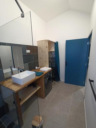 a bathroom with a sink and a blue door at Case Lénora in Saint-Joseph