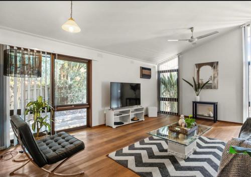 Una sala de estar con un sofá y un televisor. en Tsapas Homes, en Doncaster East