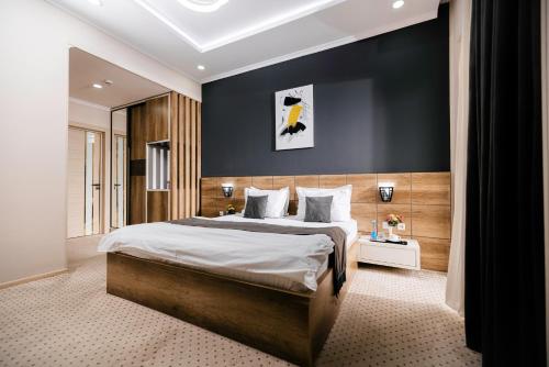 a bedroom with a large bed and a black wall at Art Regency Premium Hotel, Free Airport Shuttle Service in Tashkent