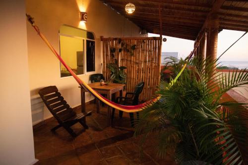 Cette chambre comprend un hamac, une table et des chaises. dans l'établissement Cielito Lindo Suites, à Puerto Escondido