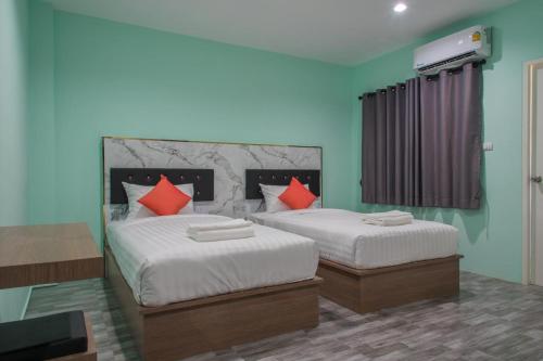 1 dormitorio con 2 camas y almohadas rojas en Anatasia Apartment Phuket en Phuket