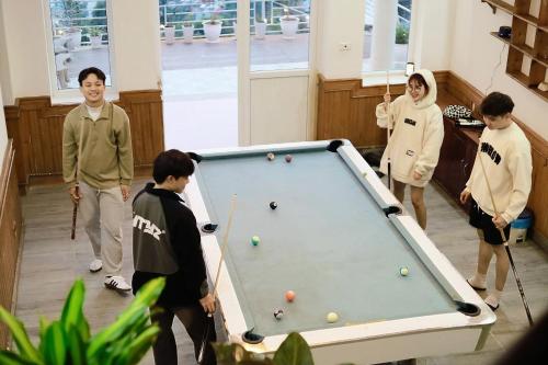 a group of people standing around a pool table at Villa Đường Mây 2 in Tam Ðảo