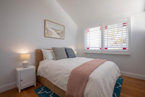 a small bedroom with a bed and a window at Seaside apartment, 100m to beach in Narrabeen