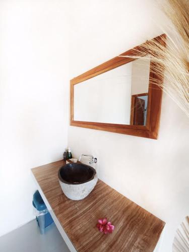 a bathroom with a sink and a mirror on a counter at Sumbul View Surfcamp in Airsatang