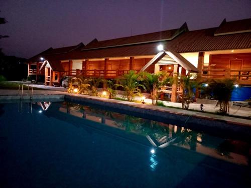 a house with a swimming pool at night at Vang Vieng Romantic Place Resort in Vang Vieng