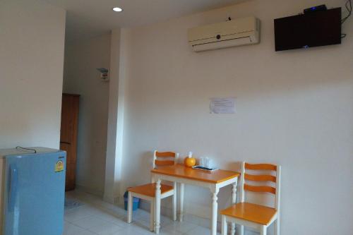 a room with a table and two chairs and a refrigerator at Review Resort in Bang Sare