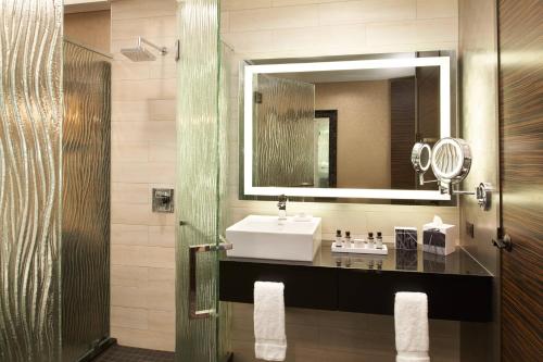 een badkamer met een wastafel en een spiegel bij Metropolitan at The 9, Autograph Collection in Cleveland