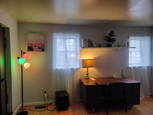 a desk in a room with a lamp and two windows at Studio in Downtown Frederick in Frederick