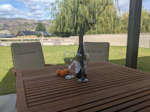 a wooden table with a vase and two glasses on it at Cozy Cottage on Begg Lane in Cromwell