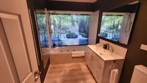 a bathroom with a tub and a sink at Dewdrop Cottage in Hastings