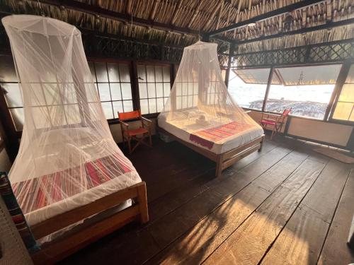 a room with two beds with mosquito net at Casa Akira- Rincón del Mar in San Onofre