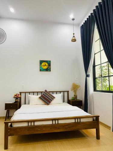 a bedroom with a bed and a large window at Romo Homestay in Quang Ngai