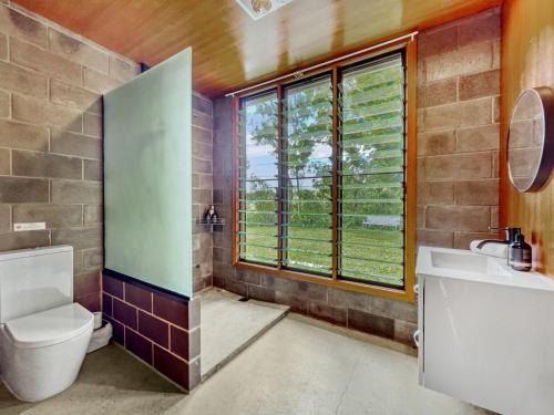 Luxurious Mountain Retreat with Studio Room في Booroobin: حمام مع مرحاض ومغسلة ونافذة