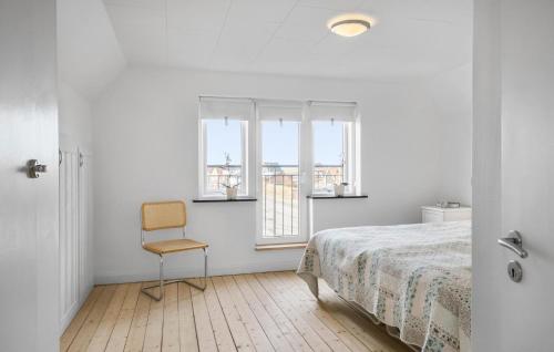 - une chambre avec un lit, une chaise et des fenêtres dans l'établissement 1 Bedroom Beautiful Apartment In Thyborn, à Thyborøn