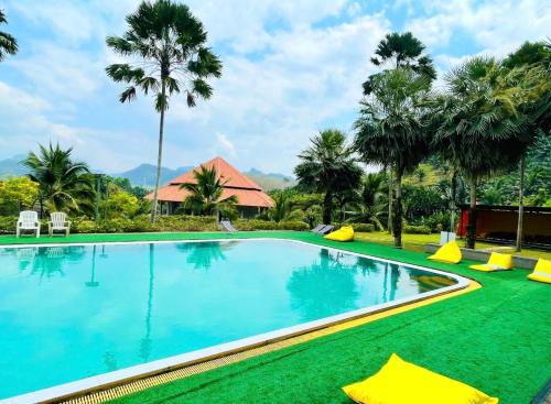 een zwembad in een resort met palmbomen bij Takhun Mountain View in Ban Tha Khun